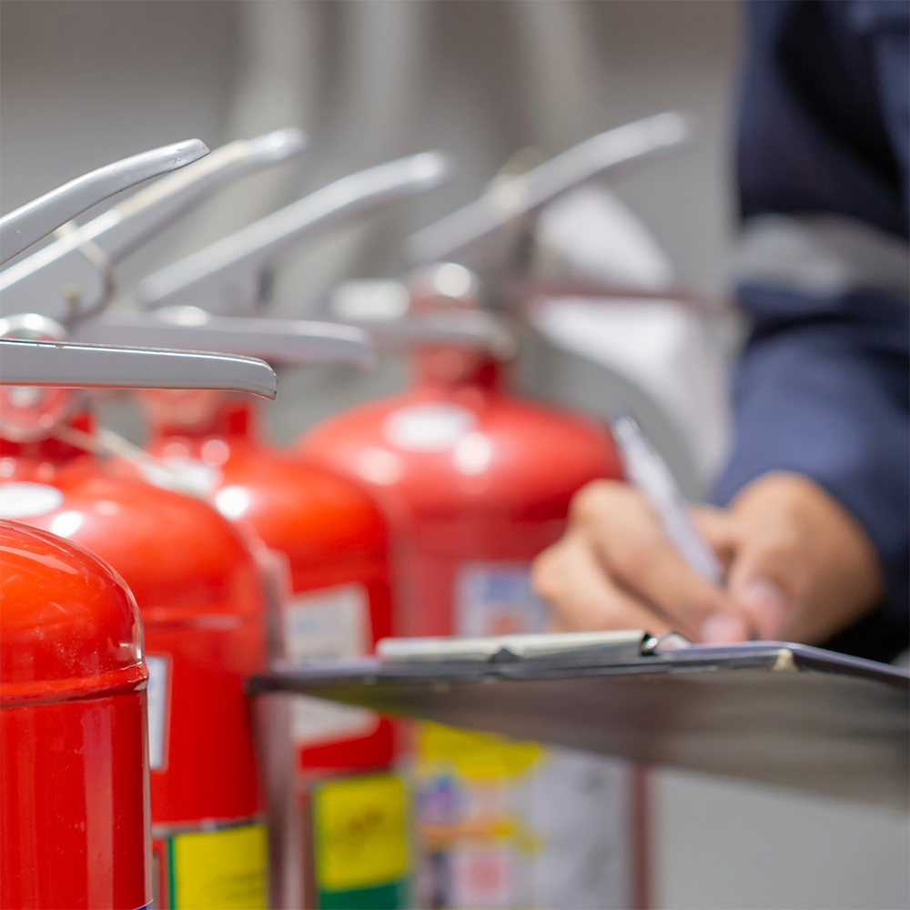 A firefighter inspecting portable fire extinguishers