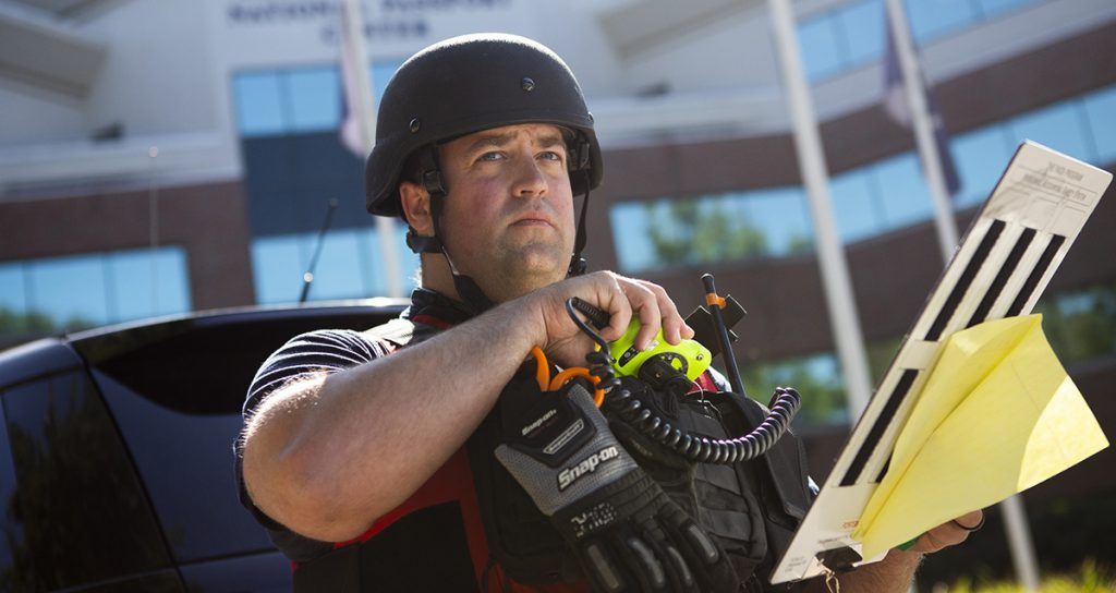 A law enforcement officer using a portable radio during a training exercise.