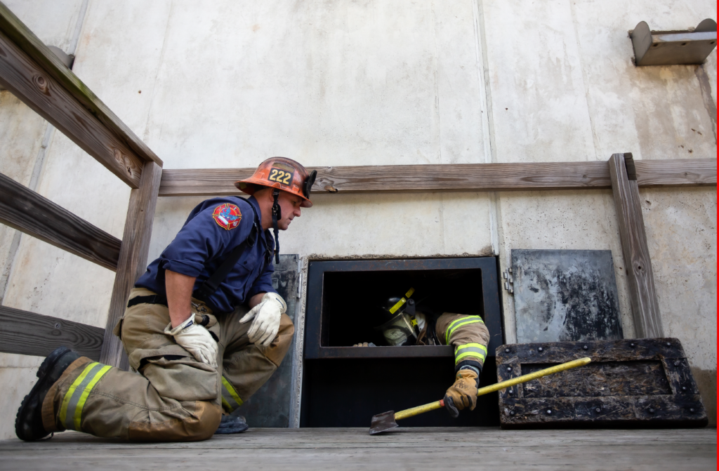 An instructor works with a fire recruit in the drillyard