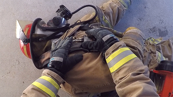 A POV view of a firefighter assessing a downed team member